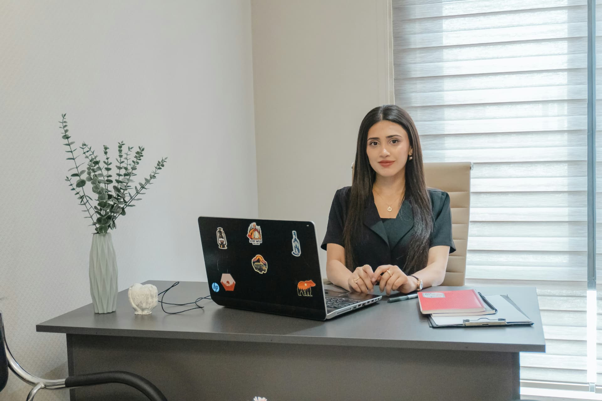 Docente trabajando con su laptop en un espacio de oficina limpio y luminoso
